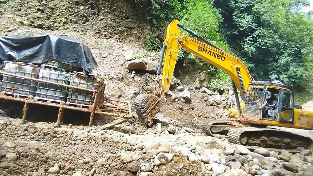 La excavadora de orugas SH240-8 navega por terrenos fangosos de la selva amazónica para transportar mercancías para clientes de América del Sur